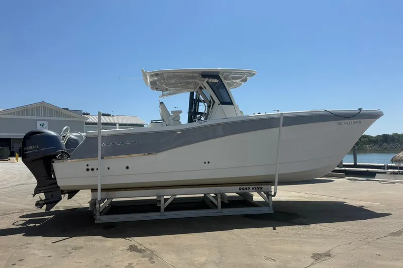 Slide: The Image of 2020 World Cat 280 CC-X boat on trailer, dockside under clear blue sky. - 6
