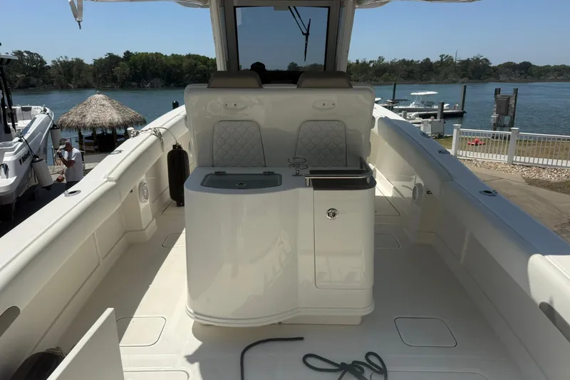 Slide: The Image of 2020 World Cat 280 CC-X boat interior with seating and console, docked by a scenic waterfront. - 7