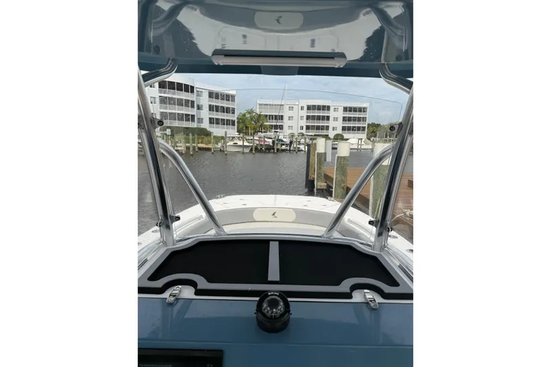 Slide: The Image of 2026 Falcon Boats 26 at marina, view from helm with buildings in background. - 17