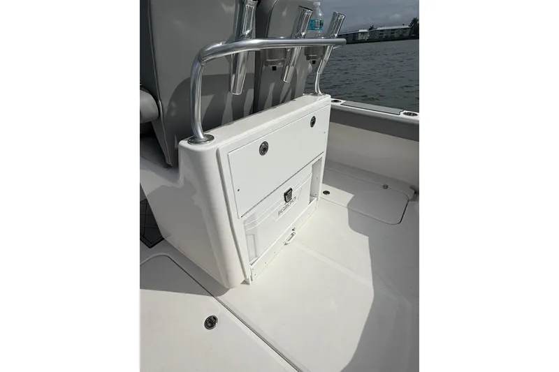 Slide: The Image of 2026 Falcon Boats 26 interior with storage compartment and rod holders on a sunny day. - 4