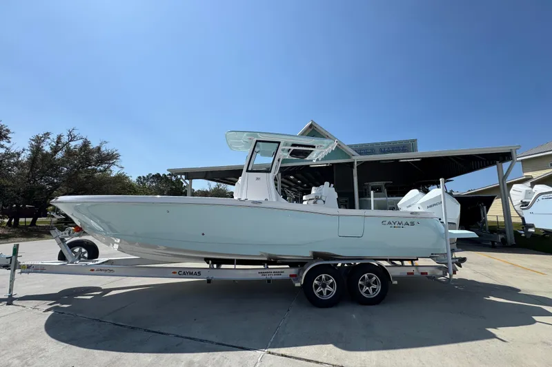 The Image of 2026 Caymas 291 boat on trailer under clear blue sky. - 1