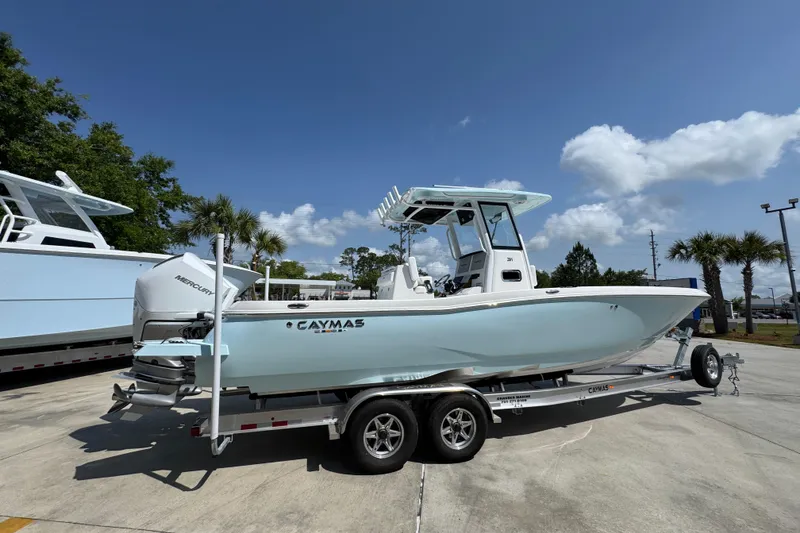 Slide: The Image of 2026 Caymas 291 boat on trailer under clear blue sky. - 11