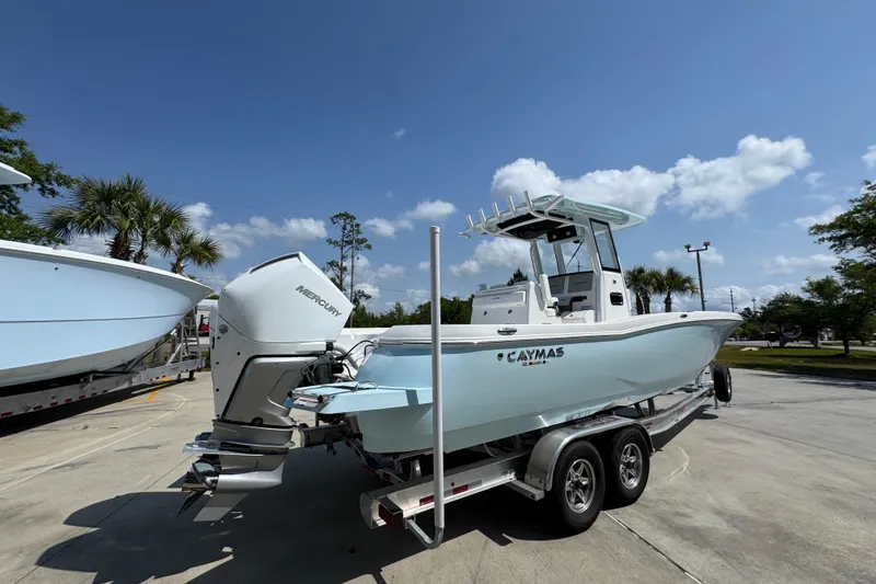 Slide: The Image of 2026 Caymas 291 boat on trailer, featuring Mercury engine, under clear blue sky. - 12