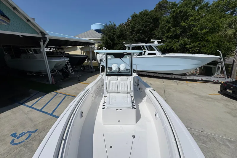 Slide: The Image of 2026 Caymas 291 boat displayed outdoors, surrounded by other boats and trees. - 21