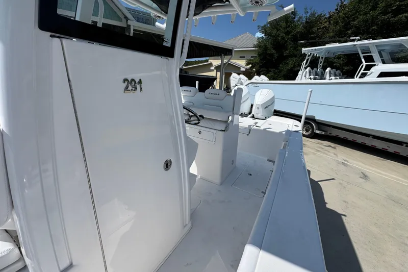 Slide: The Image of 2026 Caymas 291 boat interior with seating and console, docked outdoors. - 23