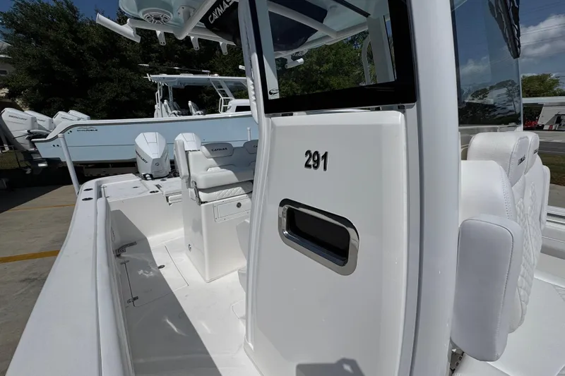 Slide: The Image of 2026 Caymas 291 boat interior with white seating and console, docked outdoors. - 24