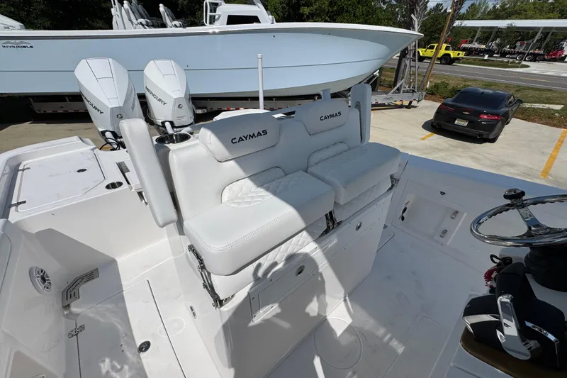 Slide: The Image of 2026 Caymas 291 boat interior with dual Mercury engines and white seating. - 27