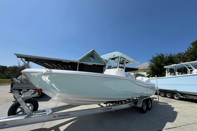 Slide: The Image of 2026 Caymas 291 boat on trailer under clear blue sky. - 3