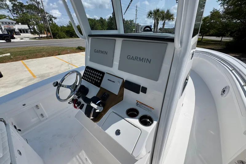 Slide: The Image of 2026 Caymas 291 boat cockpit with dual Garmin displays and steering wheel. - 30