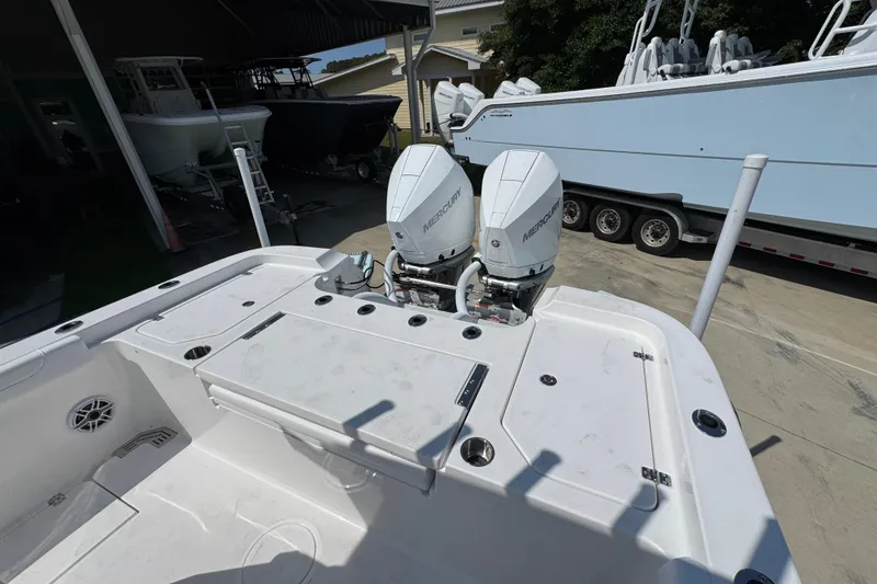 Slide: The Image of 2026 Caymas 291 boat with dual Mercury outboard engines, docked near other boats. - 34