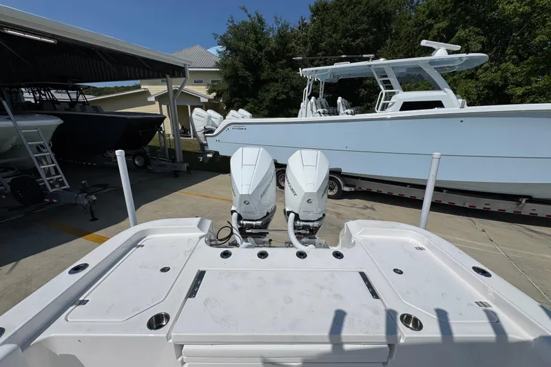 Slide: The Image of 2026 Caymas 291 boat with dual outboard motors in a marina setting. - 35