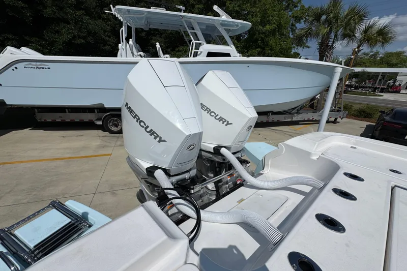 Slide: The Image of 2026 Caymas 291 boat with dual Mercury outboard engines, parked near another boat. - 37