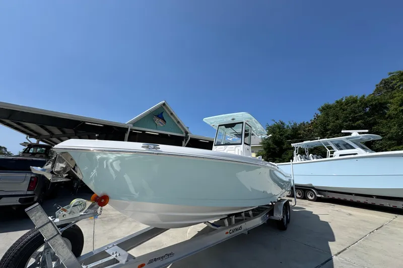 Slide: The Image of 2026 Caymas 291 boat on trailer under clear blue sky. - 4