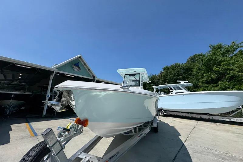 Slide: The Image of 2026 Caymas 291 boat on trailer, parked outdoors under clear blue sky. - 5