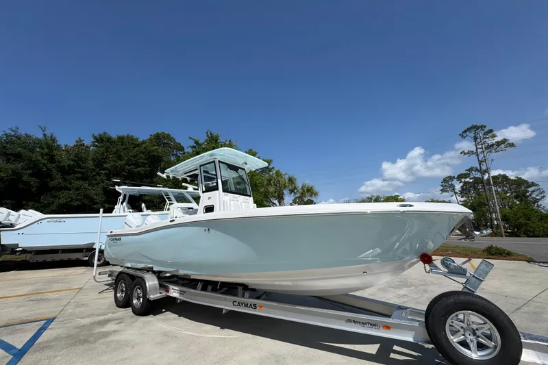 Slide: The Image of 2026 Caymas 291 boat on trailer under clear blue sky. - 8