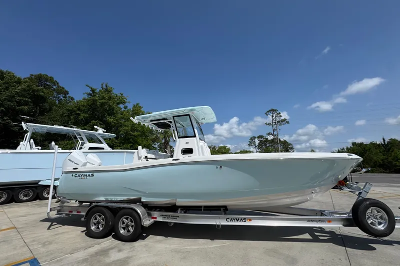 Slide: The Image of 2026 Caymas 291 boat on trailer under clear blue sky. - 9