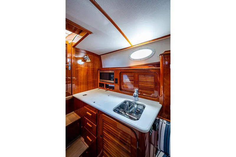 Slide: The Image of 2013 Hinckley Picnic Boat 37 MKIII interior galley with sink and wooden cabinetry. - 15