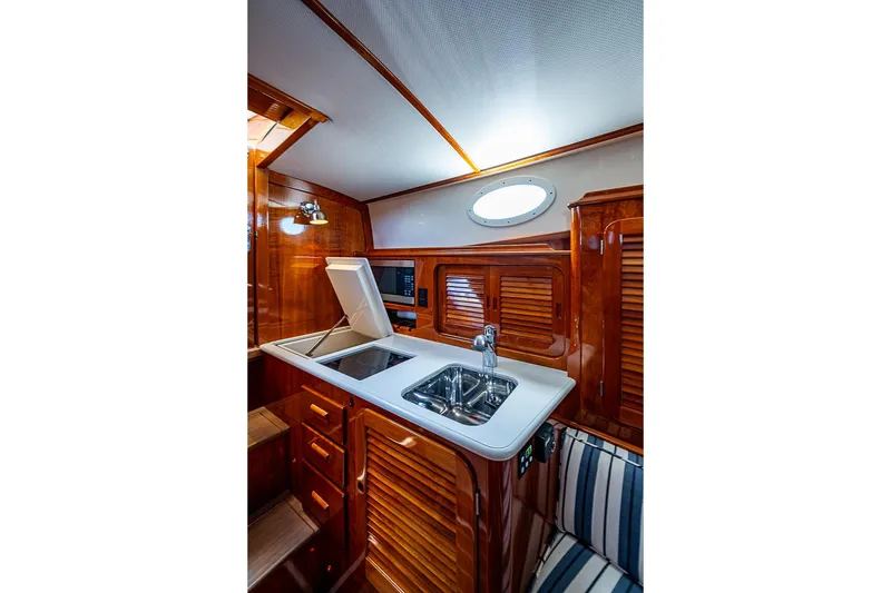Slide: The Image of Luxurious wooden interior of 2013 Hinckley Picnic Boat 37 MKIII galley with sink and stove. - 16