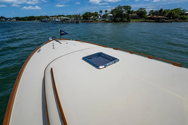 Slide: The Image of Hinckley Picnic Boat 37 MKIII 2013 cruising on a scenic waterway under a clear sky. - 20