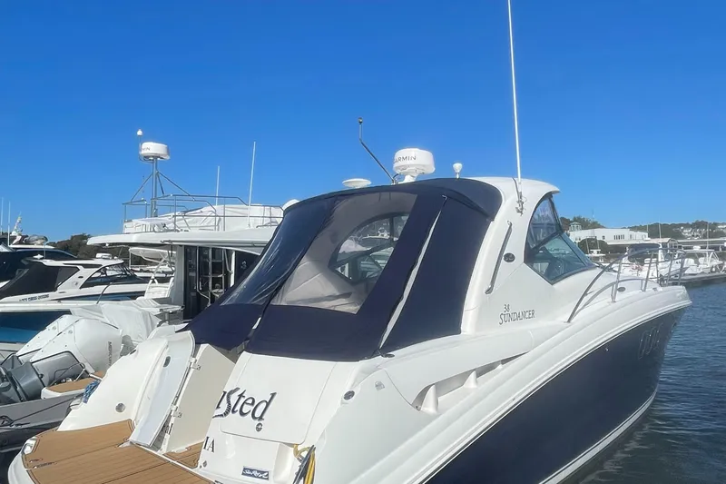 The Image of 2006 Sea Ray 380 Sundancer yacht docked at marina under clear blue sky. - 0