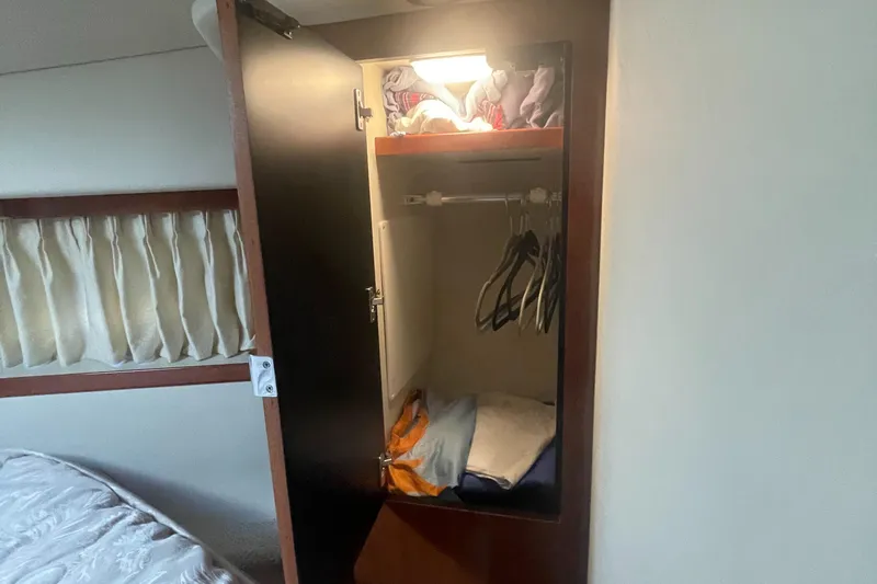 Slide: The Image of Open closet in 2006 Sea Ray 380 Sundancer with clothes and hangers inside. - 14