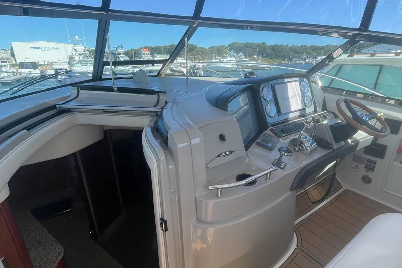 Slide: The Image of 2006 Sea Ray 380 Sundancer helm with modern navigation equipment and spacious cockpit view. - 20