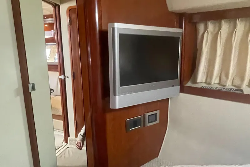 Slide: The Image of Interior of 2006 Sea Ray 380 Sundancer with wall-mounted TV and wooden paneling. - 21