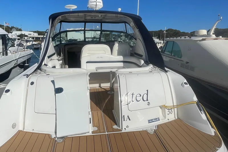 Slide: The Image of 2006 Sea Ray 380 Sundancer yacht docked at marina, featuring open deck and seating area. - 26