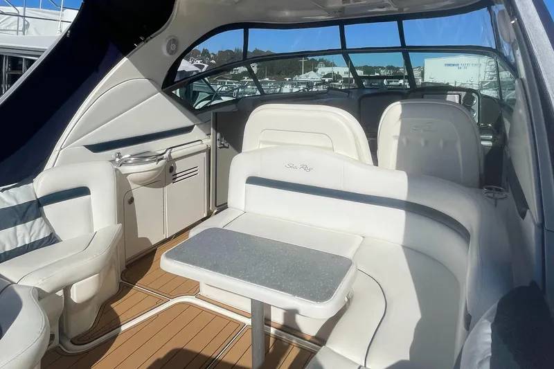 Slide: The Image of 2006 Sea Ray 380 Sundancer interior with white seating and table, featuring sleek design and wood flooring. - 28