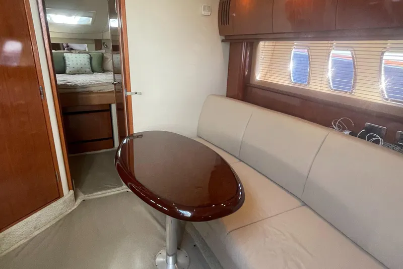 Slide: The Image of Interior of 2006 Sea Ray 380 Sundancer with beige sofa and wooden table. - 7