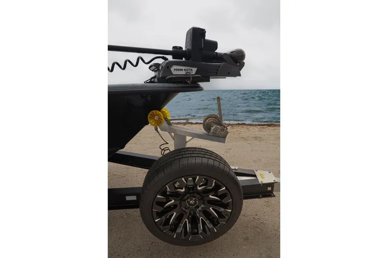 Slide: The Image of 2025 Haynie 24 High Output boat trailer with Minn Kota motor by the beach. - 10