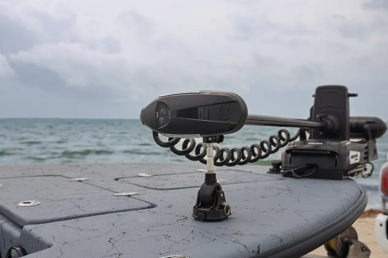 Slide: The Image of 2025 Haynie 24 High Output boat with advanced trolling motor on a calm sea backdrop. - 11