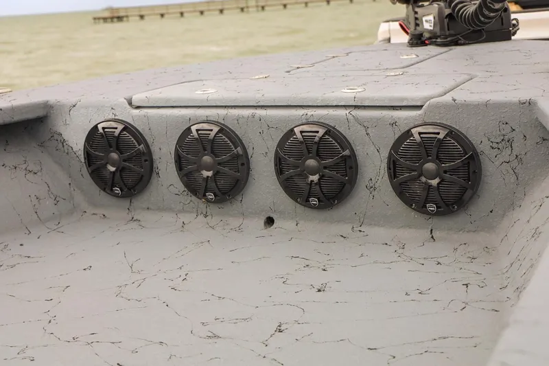 Slide: The Image of 2025 Haynie 24 High Output boat with four black speakers on a textured gray surface. - 13