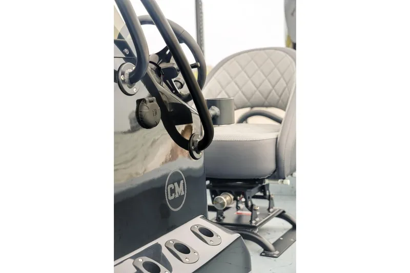 Slide: The Image of Interior of 2025 Haynie 24 High Output boat, featuring steering wheel and cushioned seat. - 18