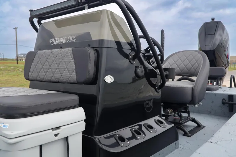 Slide: The Image of 2025 Haynie 24 High Output boat interior with sleek black console and cushioned seating. - 19