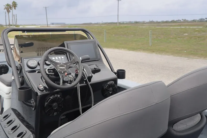 Slide: The Image of 2025 Haynie 24 High Output boat dashboard with steering wheel and navigation display. - 23