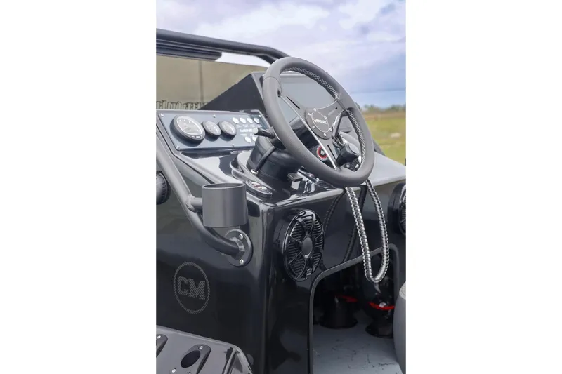 Slide: The Image of 2025 Haynie 24 High Output boat dashboard with steering wheel and control panel. - 24
