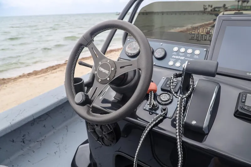 Slide: The Image of Steering console of 2025 Haynie 24 High Output boat by the beach. - 26