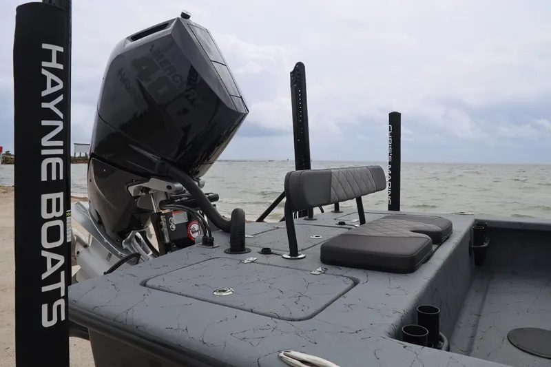 Slide: The Image of 2025 Haynie 24 High Output boat with powerful engine, docked by the sea. - 36