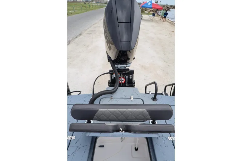 Slide: The Image of 2025 Haynie 24 High Output boat with sleek motor and cushioned seating, dockside view. - 40