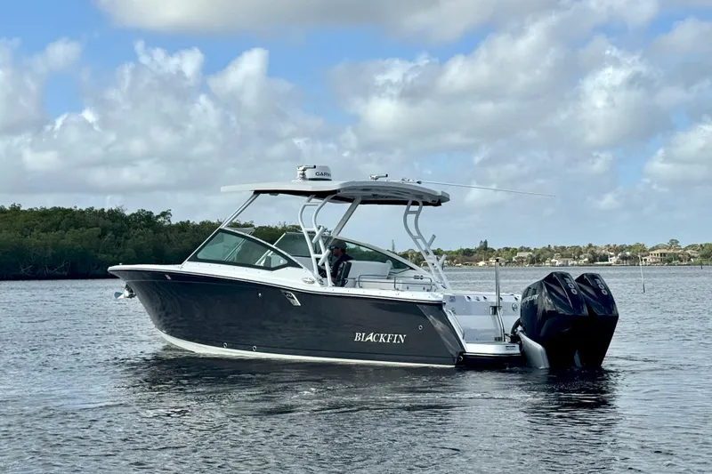 Slide: The Image of 2023 Blackfin 272 DC boat cruising on a calm waterway under a cloudy sky. - 12