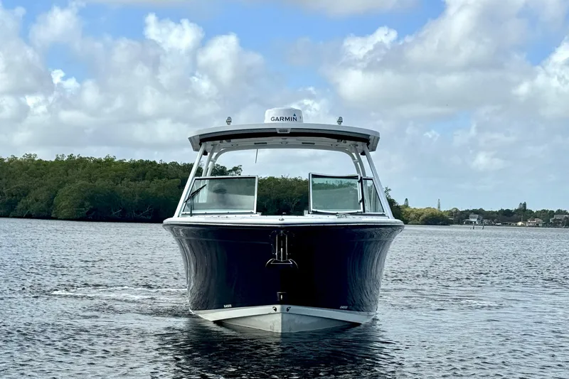 Slide: The Image of 2023 Blackfin 272 DC boat on water, front view, under cloudy sky. - 14