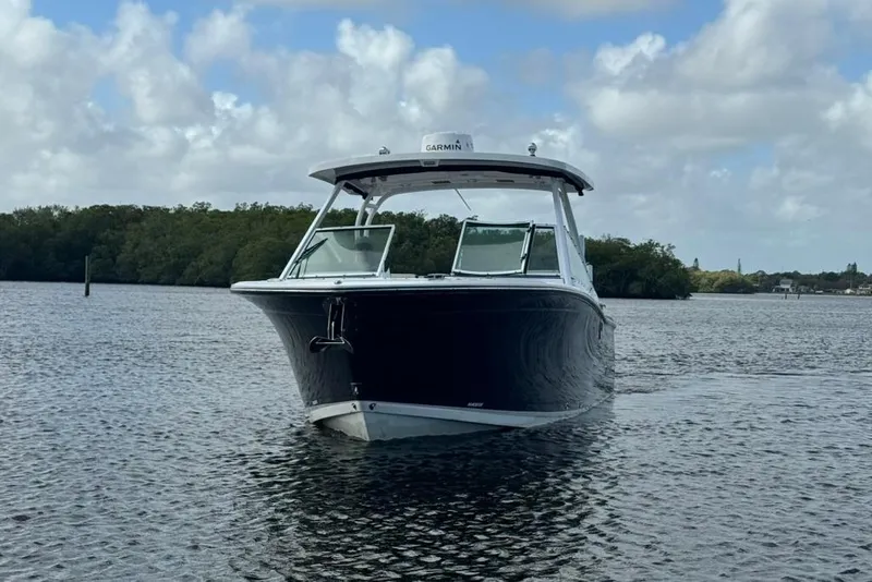 Slide: The Image of 2023 Blackfin 272 DC boat on calm water under cloudy sky. - 16
