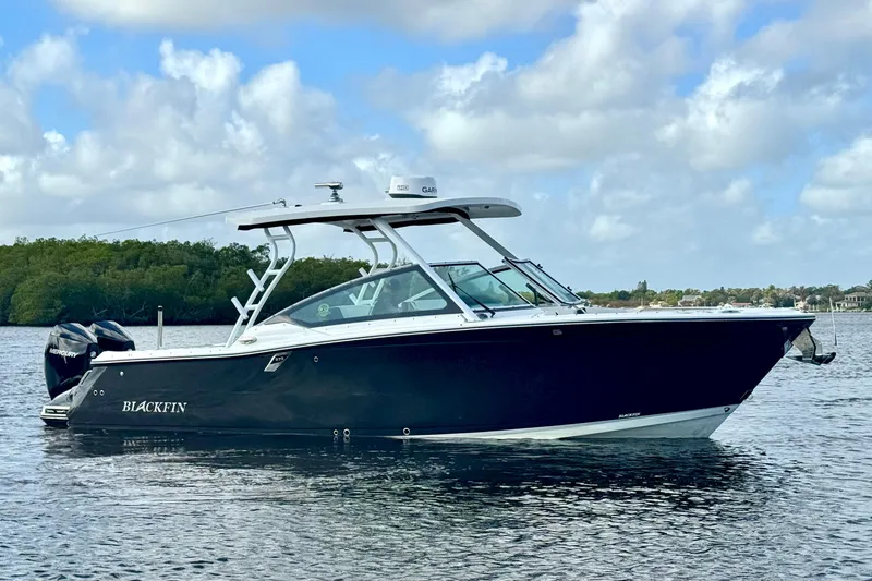 Slide: The Image of 2023 Blackfin 272 DC boat on calm water under a cloudy sky. - 18