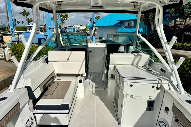 Slide: The Image of 2023 Blackfin 272 DC boat interior with seating and helm, docked at marina. - 19
