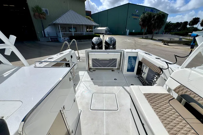 Slide: The Image of 2023 Blackfin 272 DC boat interior with seating and storage, docked near a marina. - 22