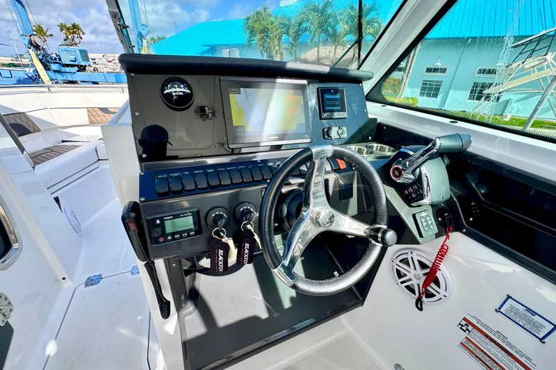 Slide: The Image of 2023 Blackfin 272 DC boat cockpit with modern steering and navigation controls. - 23