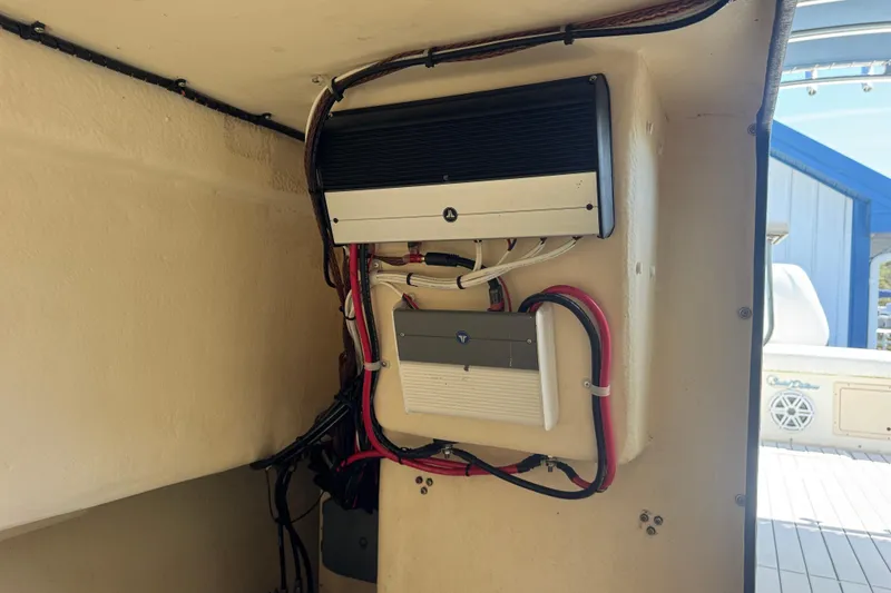 Slide: The Image of Electrical components inside a 2002 Parker 2510 Walkaround boat, showcasing wiring and equipment. - 10