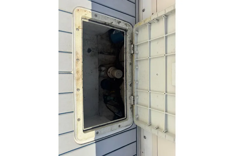 Slide: The Image of Open hatch on 2002 Parker 2510 Walkaround boat deck, revealing storage compartment. - 13