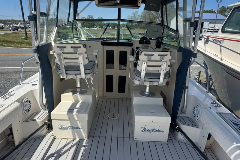 Slide: The Image of 2002 Parker 2510 Walkaround boat interior with dual captain chairs and navigation equipment. - 14